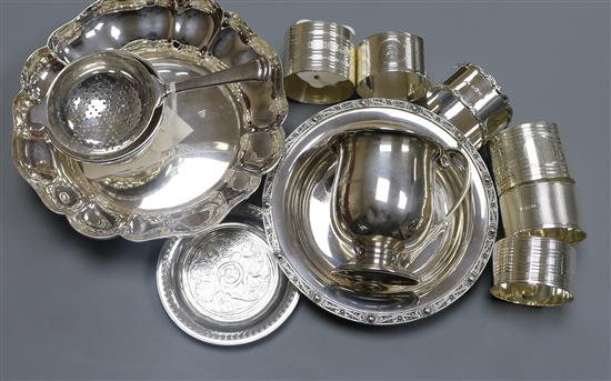 Six silver napkin rings, a tea strainer on stand, a Christening mug and three other pieces